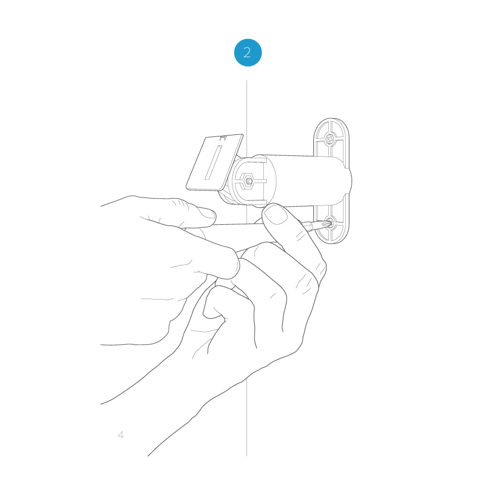 A hand holding a screwdriver and tightening the screw on the base of the mounting arm to secure it to the wall.