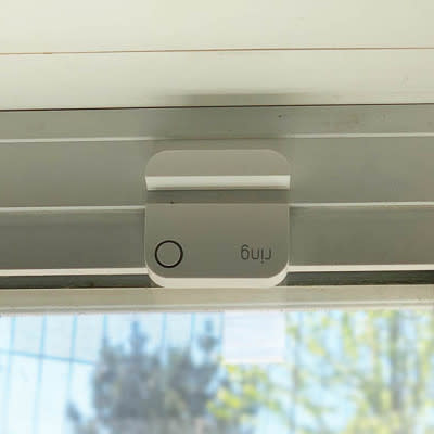 Front view of a Contact Sensor (2nd Generation) with offset mounting on a sliding glass door. 