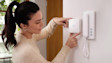 Home owner looking at Ring Intercom mounted on a wall.