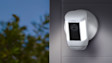 Ring security camera mounted on exterior wall with LED lights