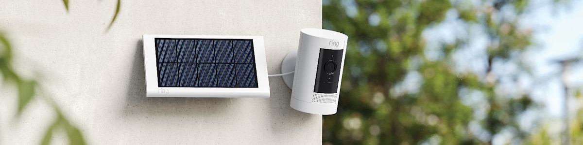 Ring security camera with solar panel mounted on white wall
