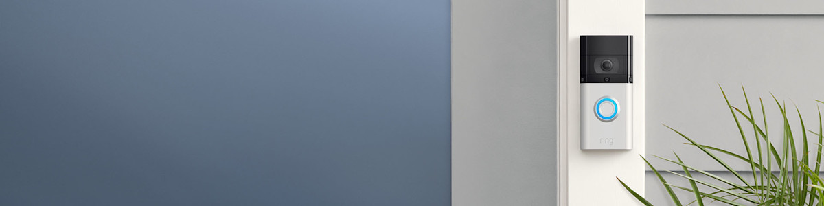 Battery Video Doorbell 3 mounted on a white wall next to green plant leaves