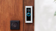 Ring Video Doorbell mounted on wooden door next to black deadbolt lock