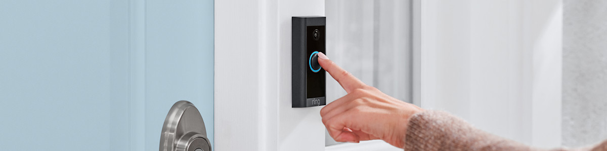 Hand pressing the illuminated doorbell button on a Ring Video Doorbell