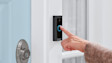 Hand pressing the illuminated doorbell button on a Ring Video Doorbell